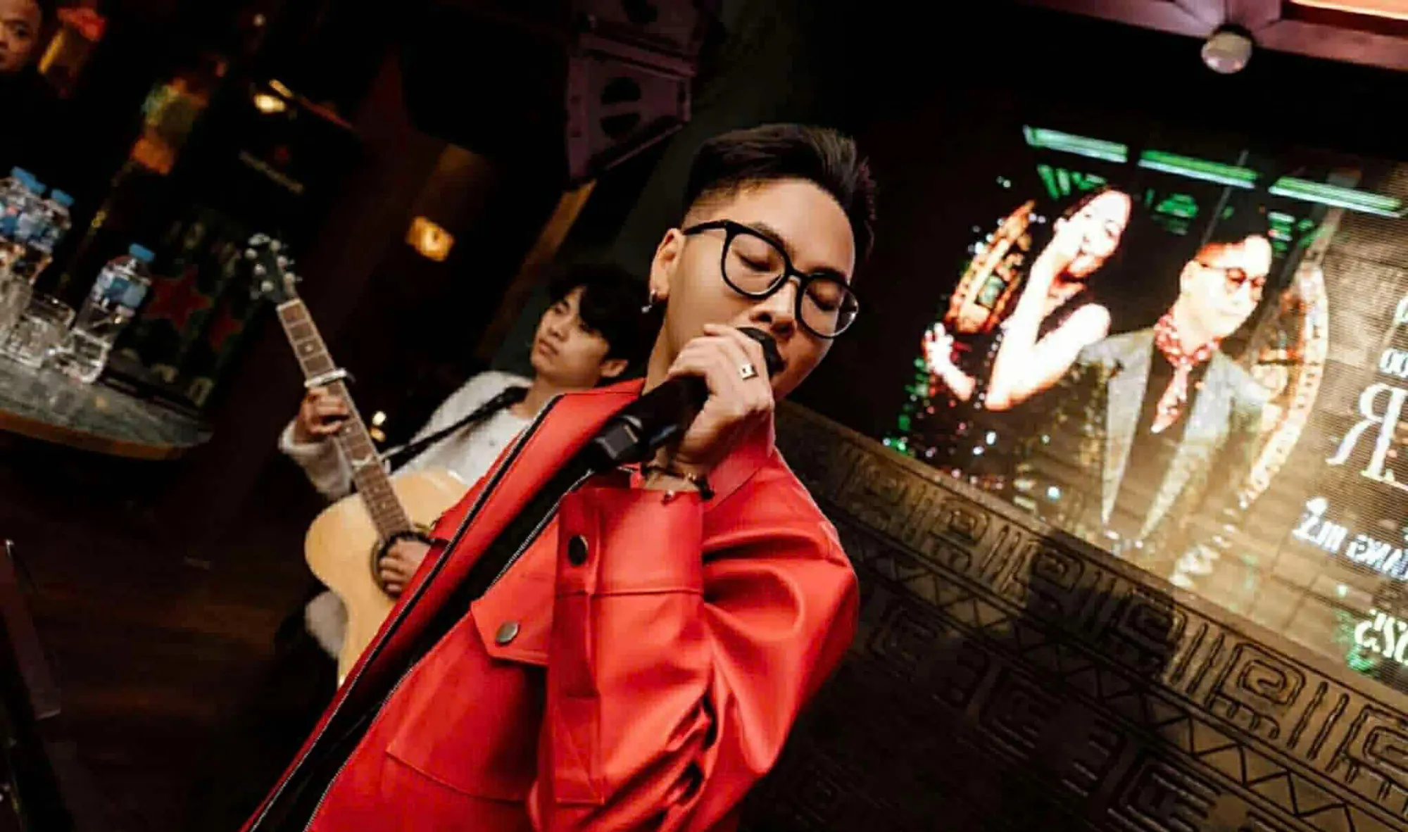 Quang Huy, ca sĩ chính The Fog Band, đang hát trên sân khấu cùng tay guitar